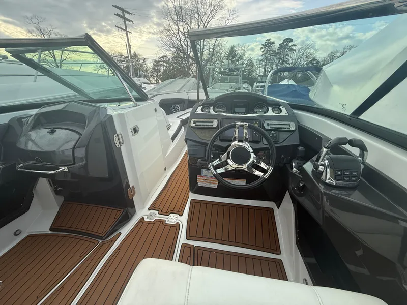 Slide: The Image of 2018 Monterey 298 Super Sport boat interior with sleek dashboard and wooden flooring. - 17