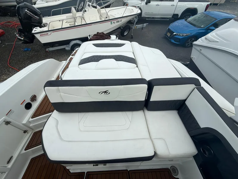 Slide: The Image of 2018 Monterey 298 Super Sport boat with white cushioned seating and wooden deck. - 24