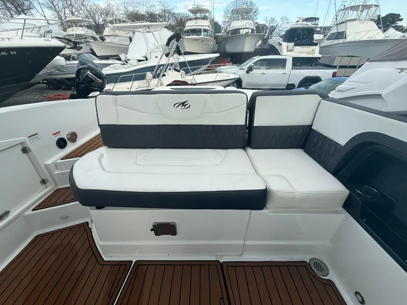 Slide: The Image of 2018 Monterey 298 Super Sport boat interior with cushioned seating and wooden deck. - 26