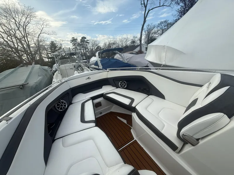 Slide: The Image of 2018 Monterey 298 Super Sport boat interior with white seating and wood flooring. - 4