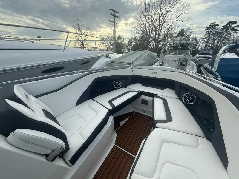 Slide: The Image of 2018 Monterey 298 Super Sport boat interior with white seating and wood flooring. - 5