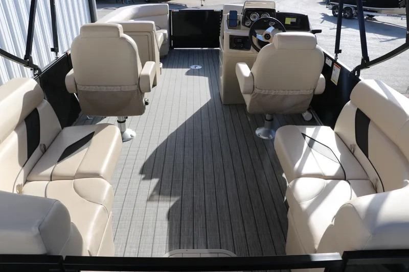 Slide: The Image of 2024 SunCatcher Select 320 RC pontoon boat interior with beige seating and modern dashboard. - 24