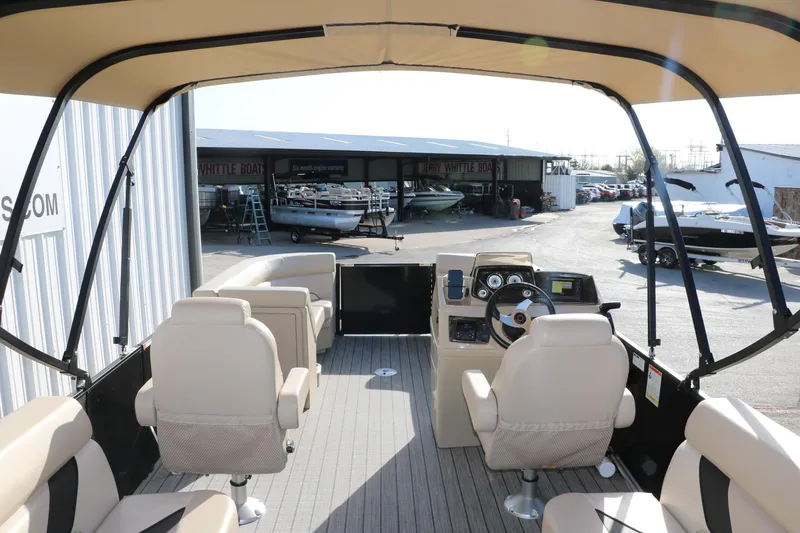 Slide: The Image of 2024 SunCatcher Select 320 RC pontoon boat interior with helm and seating, docked at marina. - 25