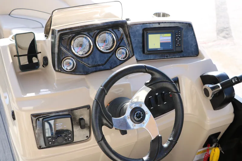 Slide: The Image of 2024 SunCatcher Select 320 RC boat dashboard with steering wheel, gauges, and navigation display. - 29