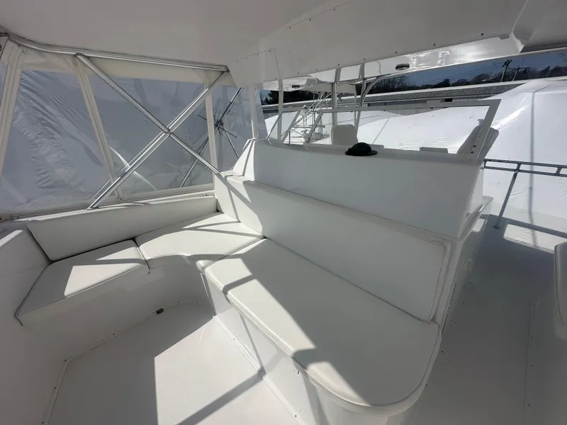 Slide: The Image of 1998 Viking 53 Convertible yacht interior with white seating and helm station. - 12