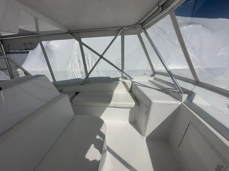 Slide: The Image of 1998 Viking 53 Convertible yacht interior with white seating and clear windows. - 13