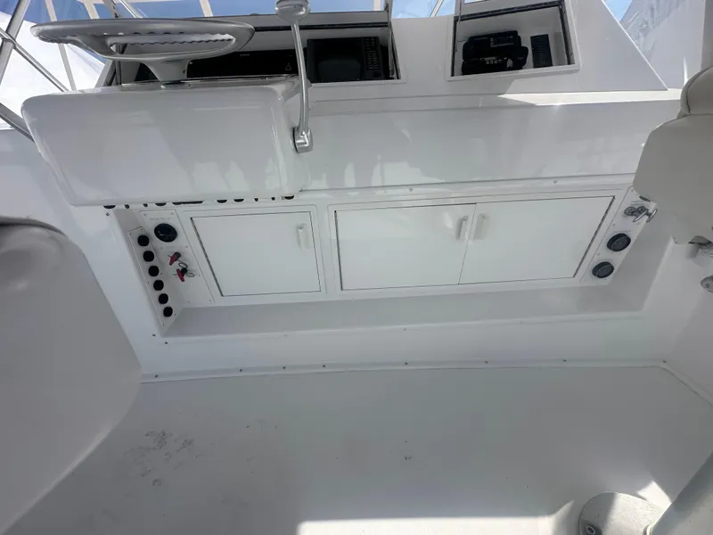 Slide: The Image of 1998 Viking 53 Convertible yacht interior with control panel and storage cabinets. - 16