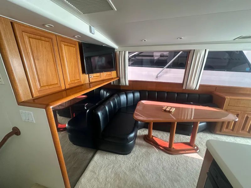 Slide: The Image of Luxurious interior of a 1998 Viking 53 Convertible yacht with leather seating and wooden cabinetry. - 19