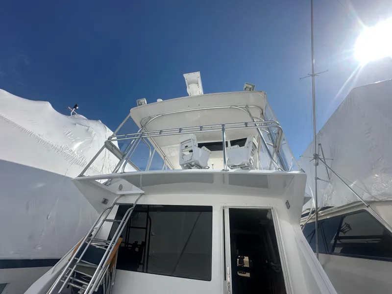 Slide: The Image of 1998 Viking 53 Convertible yacht with upper deck and ladder under clear blue sky. - 2