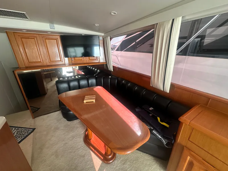 Slide: The Image of Interior of a 1998 Viking 53 Convertible yacht with leather seating and wooden table. - 20