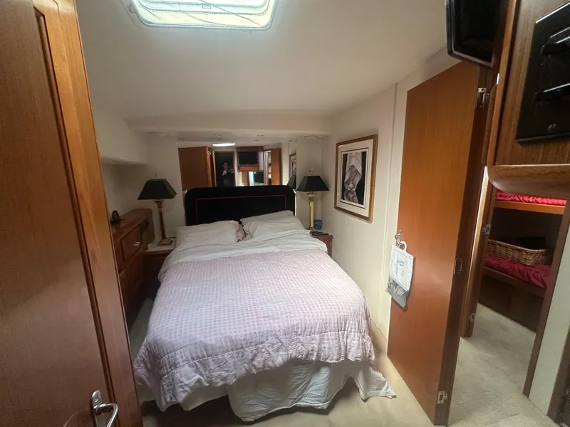 Slide: The Image of Cozy bedroom interior of 1998 Viking 53 Convertible yacht with double bed and wooden furnishings. - 27