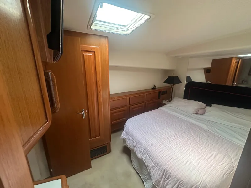Slide: The Image of Cozy bedroom in 1998 Viking 53 Convertible yacht with wooden cabinetry and skylight. - 29