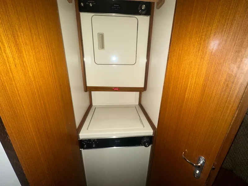 Slide: The Image of Laundry area with stacked washer and dryer in a 1998 Viking 53 Convertible boat. - 34