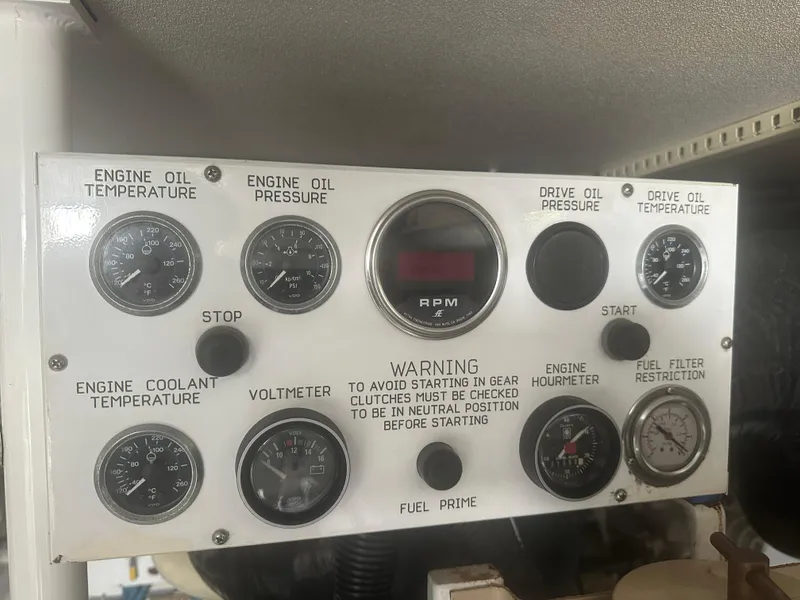 Slide: The Image of Control panel of a 1998 Viking 53 Convertible boat with various gauges and warning labels. - 39