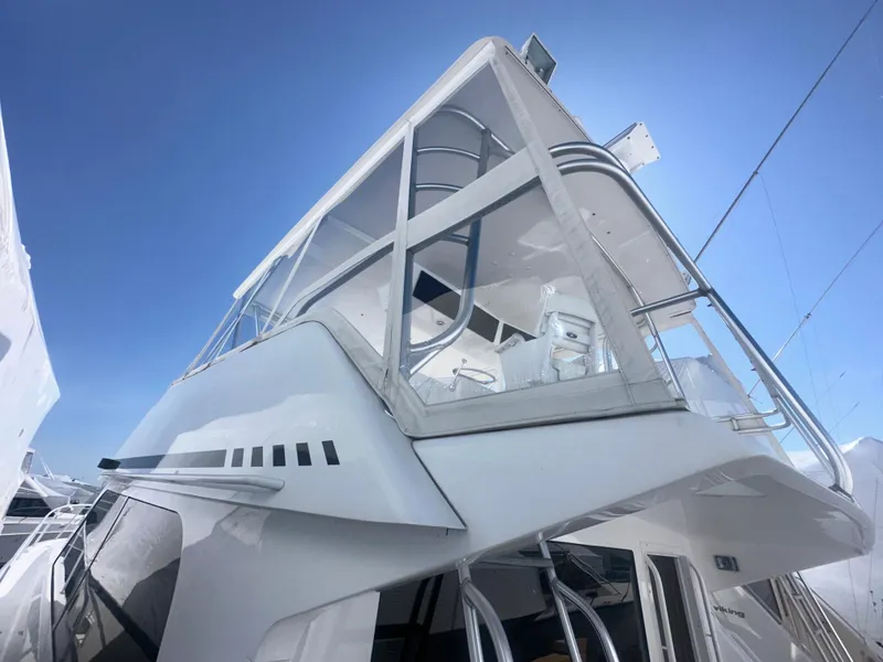 Slide: The Image of 1998 Viking 53 Convertible yacht, sleek design, upper deck view, clear blue sky background. - 4