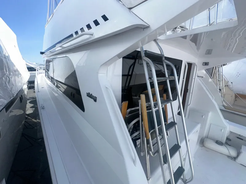 Slide: The Image of 1998 Viking 53 Convertible yacht with sleek design and ladder access. - 5