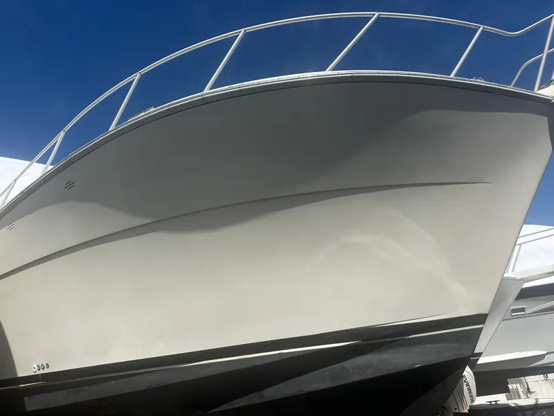 Slide: The Image of 1998 Viking 53 Convertible boat with sleek hull design under clear blue sky. - 7