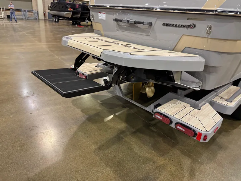 Slide: The Image of 2025 Supra SL boat with swim platform and step, displayed indoors. - 10
