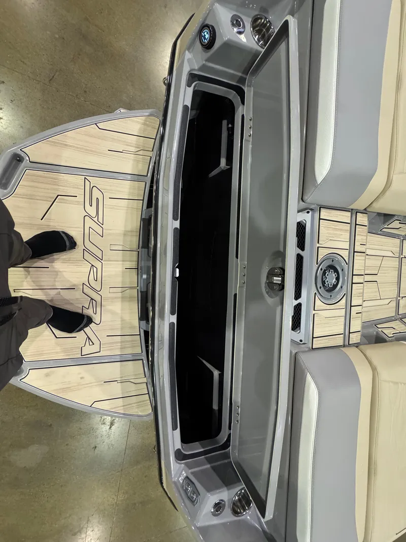 Slide: The Image of 2025 Supra SL boat interior with beige seating and wood accents, viewed from above. - 14