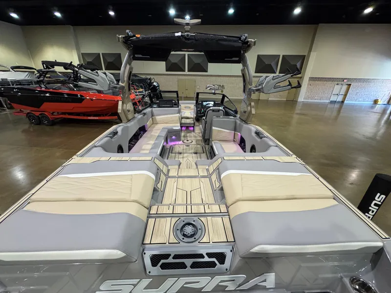Slide: The Image of 2025 Supra SL boat interior with spacious seating and modern design in a showroom. - 17