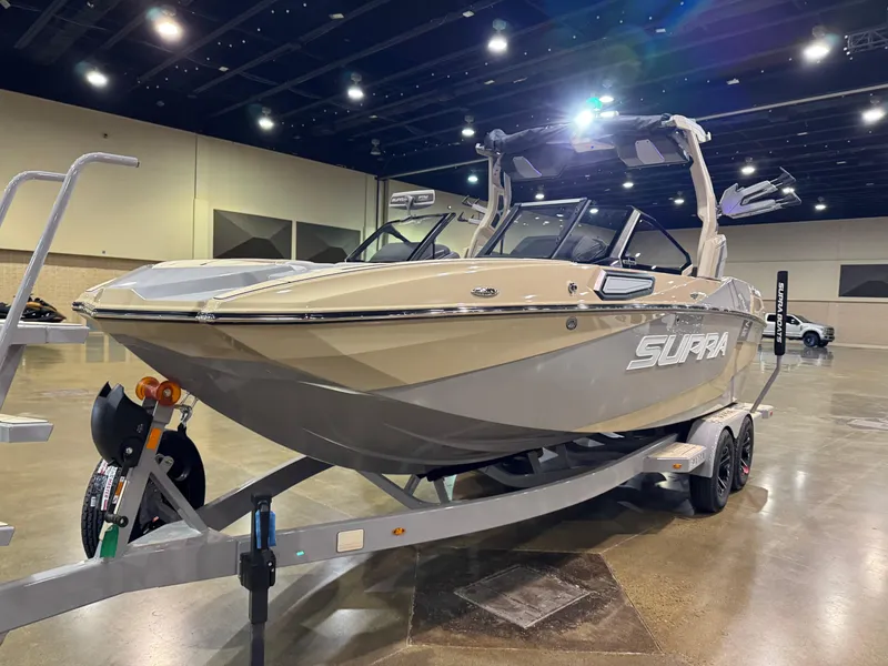 Slide: The Image of 2025 Supra SL boat on display in an indoor showroom, mounted on a trailer. - 3