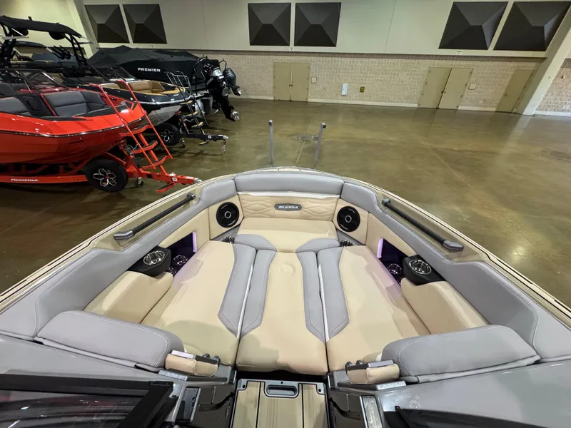 Slide: The Image of 2025 Supra SL boat interior with beige seating and speakers in a showroom. - 39