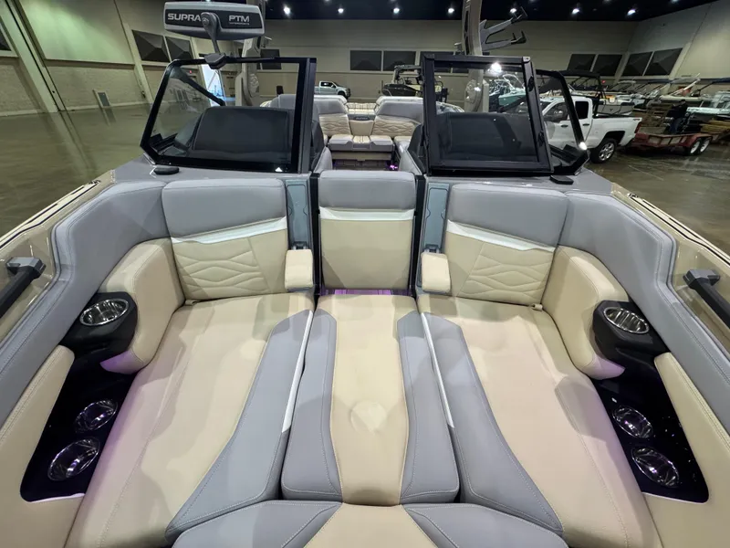 Slide: The Image of 2025 Supra SL boat interior with luxurious seating and cup holders in a showroom setting. - 43