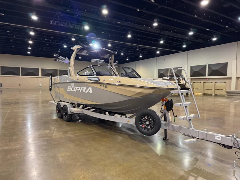 Slide: The Image of 2025 Supra SL boat on trailer in spacious indoor venue. - 5