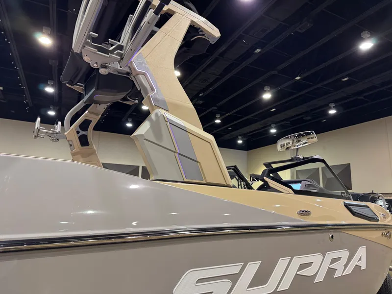 Slide: The Image of 2025 Supra SL boat with sleek design, showcased indoors under bright lighting. - 8