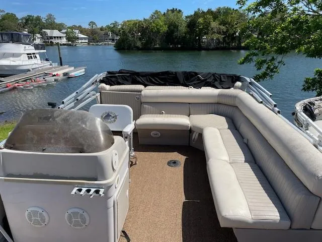 Slide: The Image of 2006 SunChaser 820 4pt Fish pontoon boat with spacious seating, docked by a scenic lake. - 2