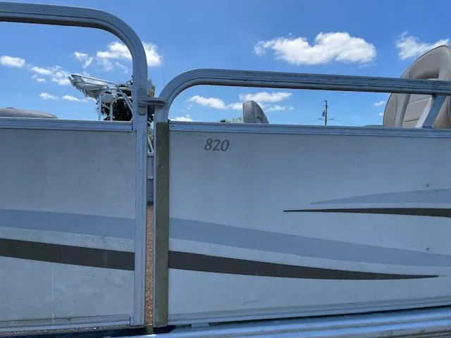 Slide: The Image of 2006 SunChaser 820 4pt Fish pontoon boat side view under blue sky. - 8
