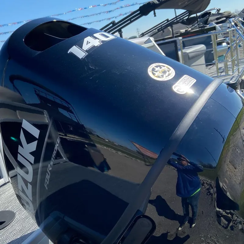 Slide: The Image of Outboard motor on 2024 Godfrey Sweetwater SW2286SFL pontoon boat, featuring Suzuki branding. - 9