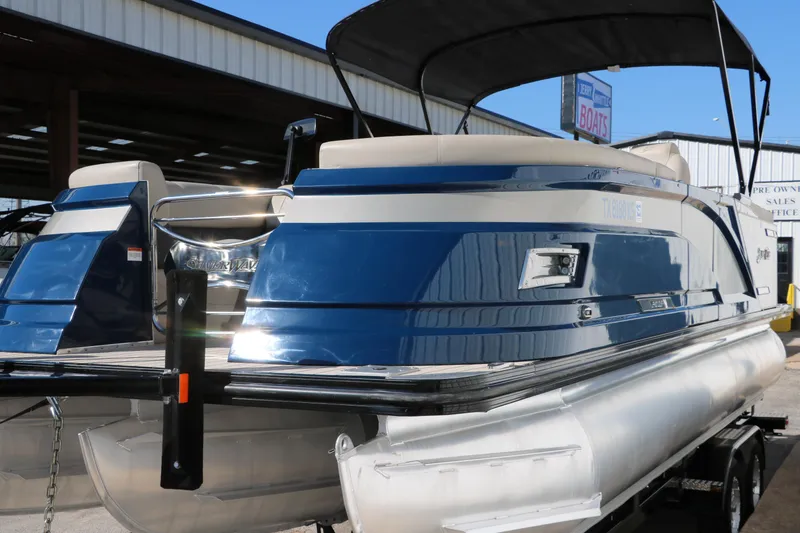 Slide: The Image of 2022 Silver Wave 2410 SW5 CLS pontoon boat with blue and white exterior, docked under a canopy. - 12
