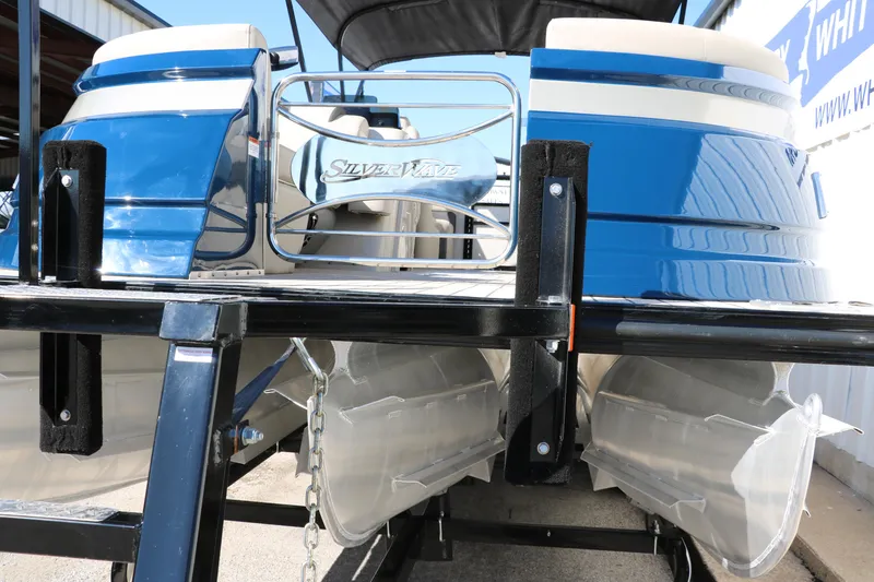 Slide: The Image of 2022 Silver Wave 2410 SW5 CLS pontoon boat on trailer, blue and white design. - 14