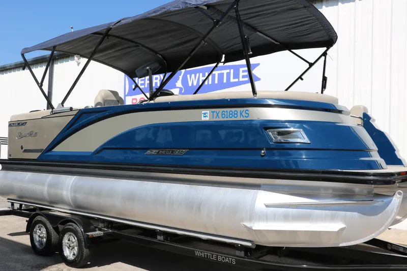 Slide: The Image of 2022 Silver Wave 2410 SW5 CLS pontoon boat with blue and beige design on trailer. - 2