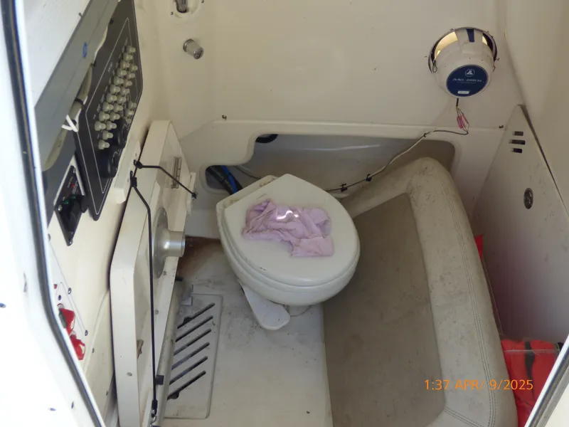 Slide: The Image of Interior of a 2018 Boston Whaler 250 Outrage boat, featuring a compact marine toilet. - 29