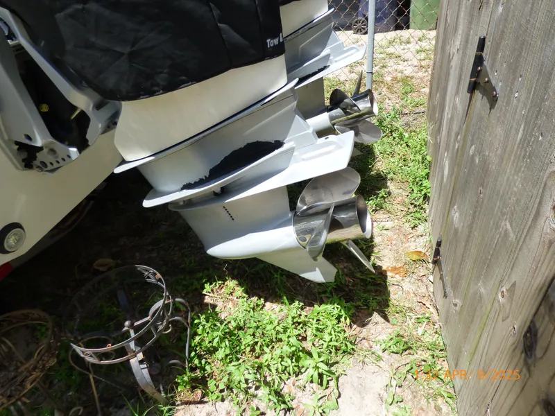 Slide: The Image of Outboard motors of a 2018 Boston Whaler 250 Outrage, parked near a wooden fence. - 16