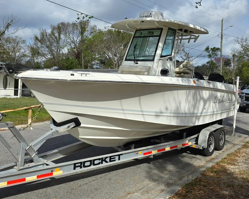 The Image of 2018 Boston Whaler 250 Outrage boat on a trailer, parked on a street. - 0