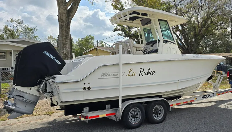 Slide: The Image of 2018 Boston Whaler 250 Outrage boat on trailer, named "La Rubia," with Mercury engine. - 6