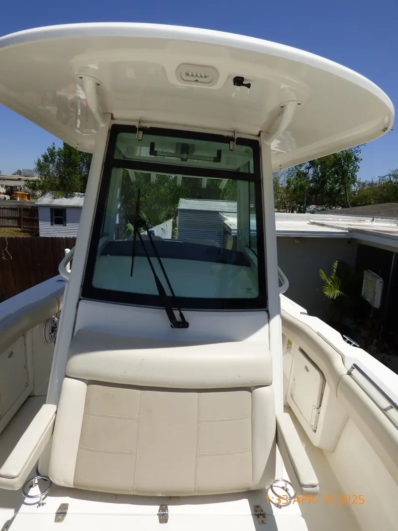 Slide: The Image of 2018 Boston Whaler 250 Outrage boat with T-top and windshield, docked outdoors. - 23