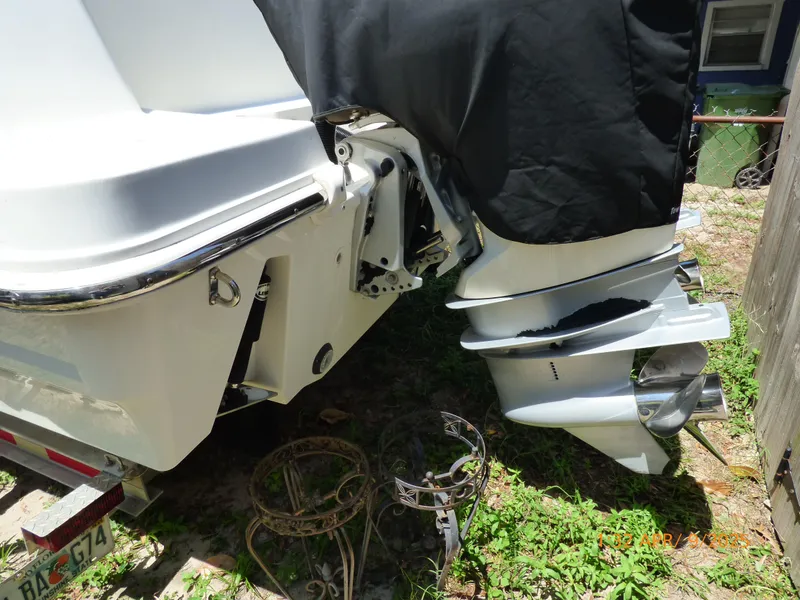 Slide: The Image of 2018 Boston Whaler 250 Outrage boat with covered outboard motor, parked on grass. - 15