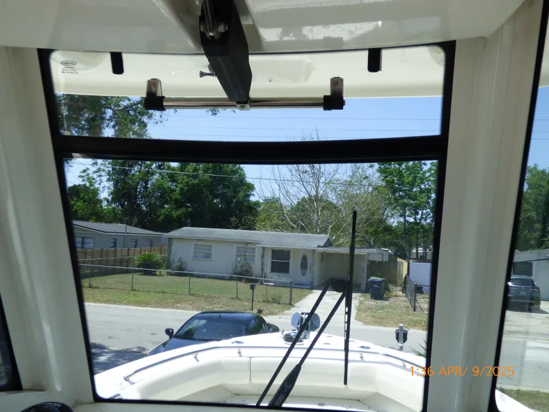 Slide: The Image of 2018 Boston Whaler 250 Outrage boat interior view through windshield, parked in residential area. - 27