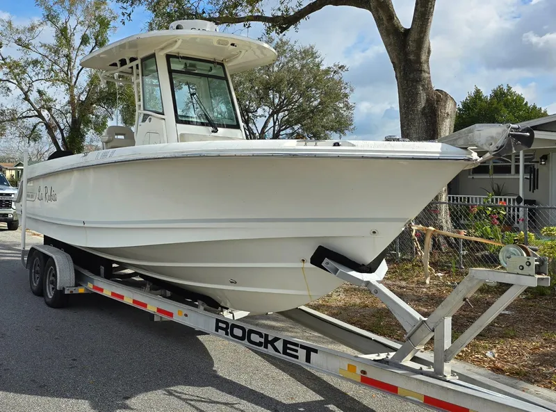 Slide: The Image of 2018 Boston Whaler 250 Outrage boat on a trailer, parked outdoors. - 7