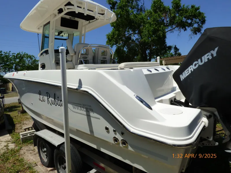 Slide: The Image of 2018 Boston Whaler 250 Outrage boat on trailer, featuring Mercury engine, sunny day. - 19