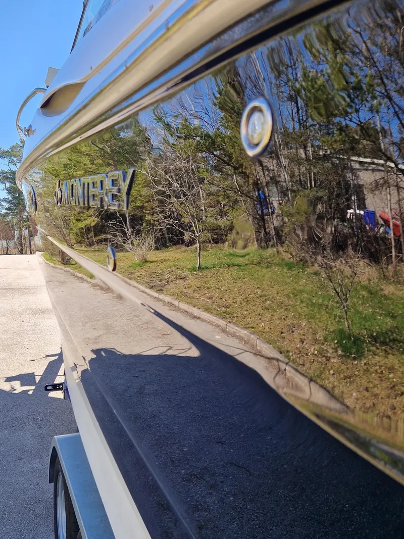 Slide: The Image of 2006 Monterey 270 Cruiser boat reflecting trees and sky, parked on a trailer. - 13