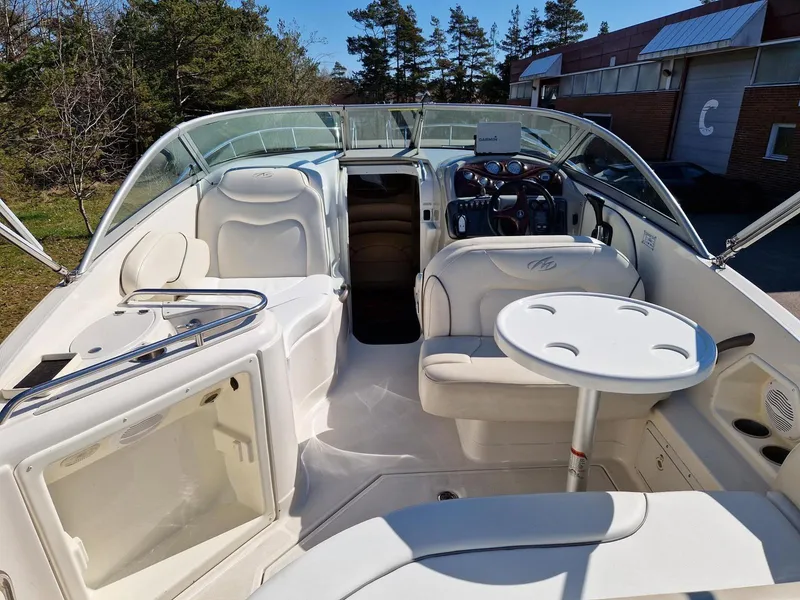 Slide: The Image of 2006 Monterey 270 Cruiser boat interior with seating and table, surrounded by trees and buildings. - 15