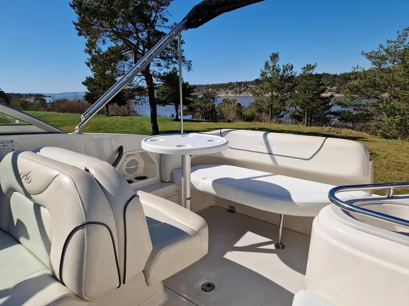 Slide: The Image of 2006 Monterey 270 Cruiser interior with seating and table, set against a scenic lakeside backdrop. - 16