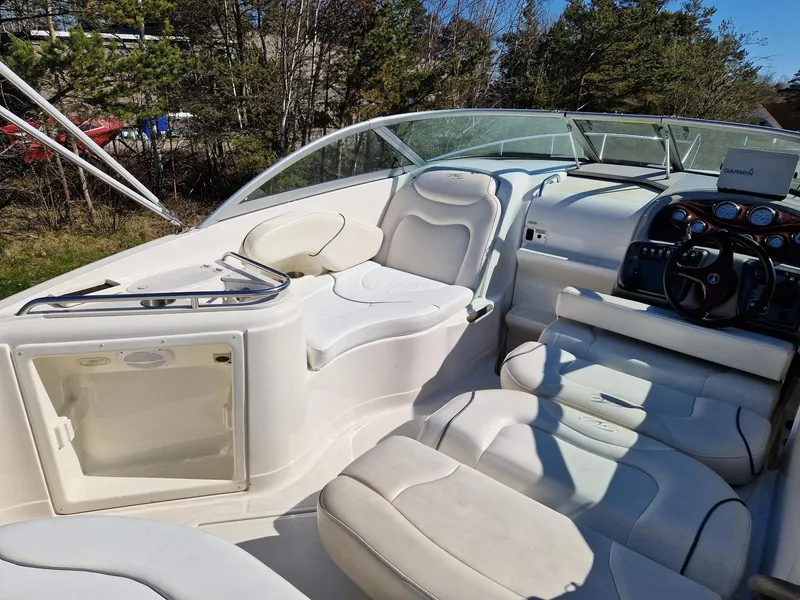 Slide: The Image of 2006 Monterey 270 Cruiser interior with white seating and control panel, surrounded by trees. - 17