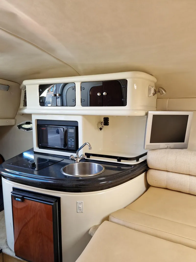 Slide: The Image of 2006 Monterey 270 Cruiser interior with kitchenette, sink, microwave, and seating area. - 22