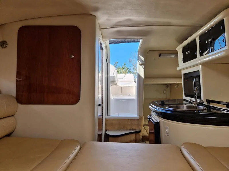 Slide: The Image of Interior of 2006 Monterey 270 Cruiser, featuring kitchenette and seating area with outdoor view. - 25